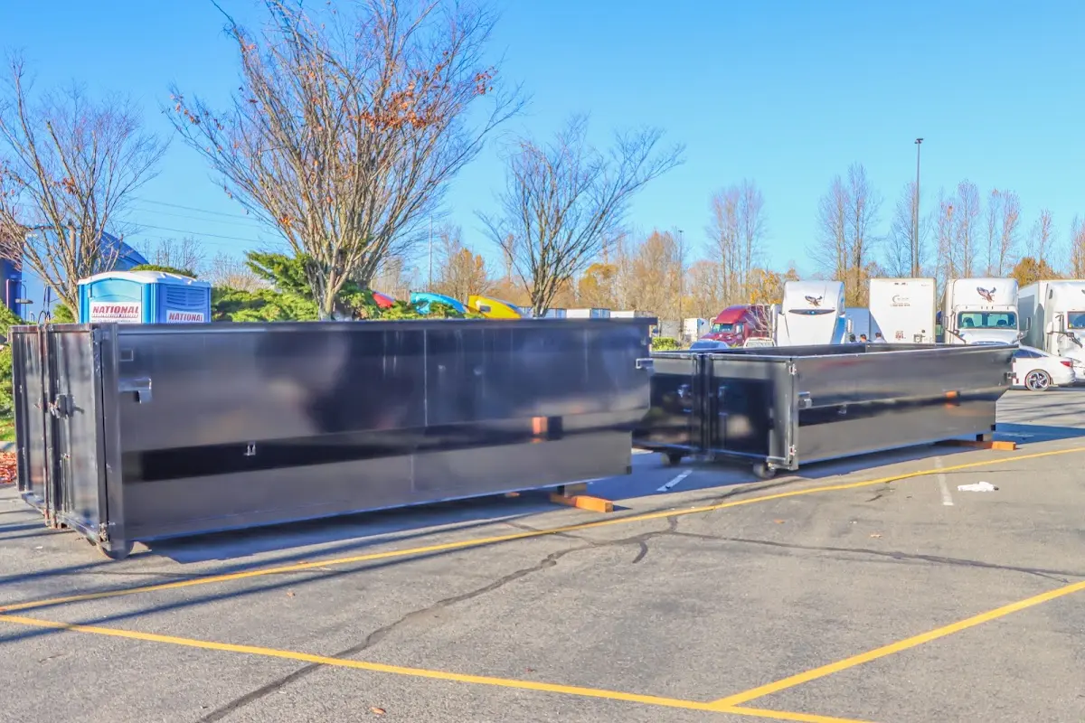 Professional dumpster rental service with roll-off container on residential driveway in Muncie